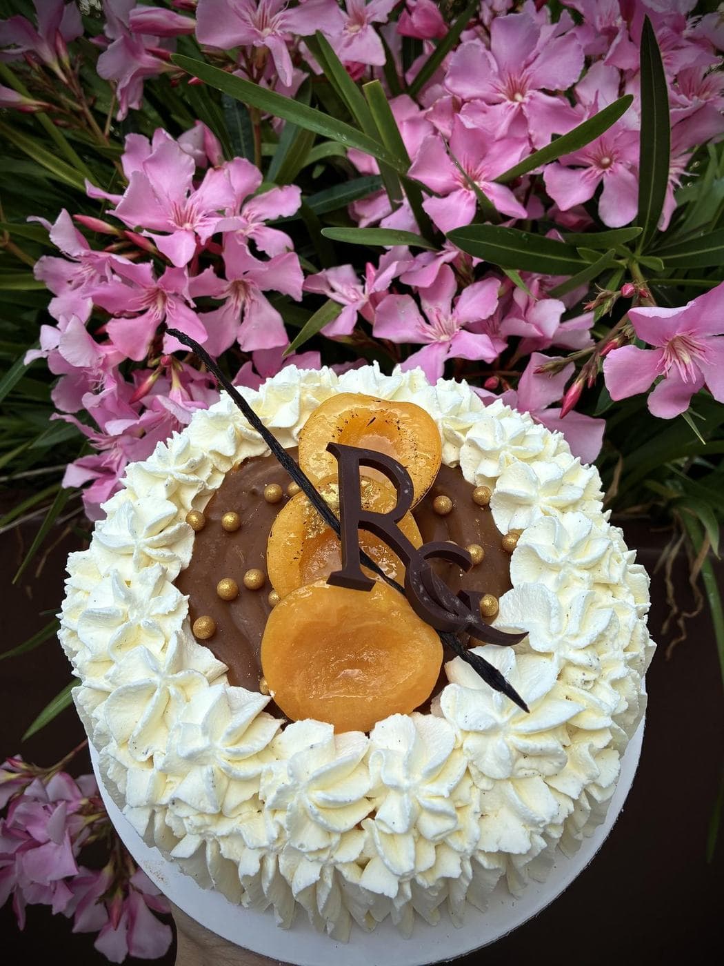 Gâteau d’anniversaire à l’abricot décoré de fleurs roses et de crème chantilly